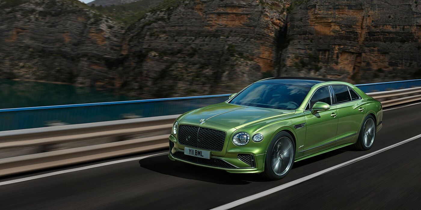 Bentley Santo Domingo Bentley New Flying Spur Speed v8 hybrid sedan driving dynamically on a mountain road in Tourmaline Green paint