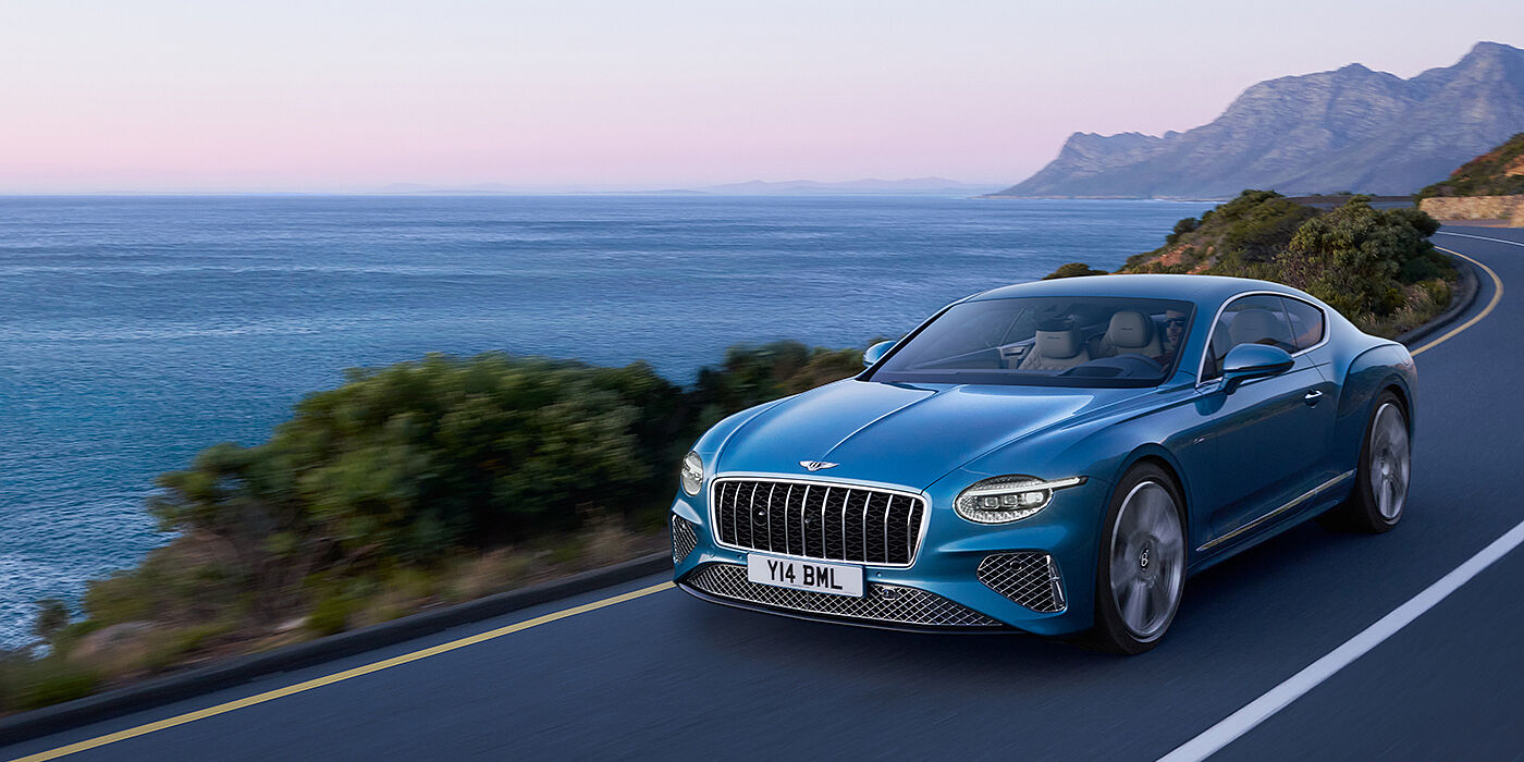 Bentley Santo Domingo New Bentley Continental GT Azure coupe in Light Windsor blue paint with 22 inch Azure wheels and chrome grill, driving dynamically by the sea